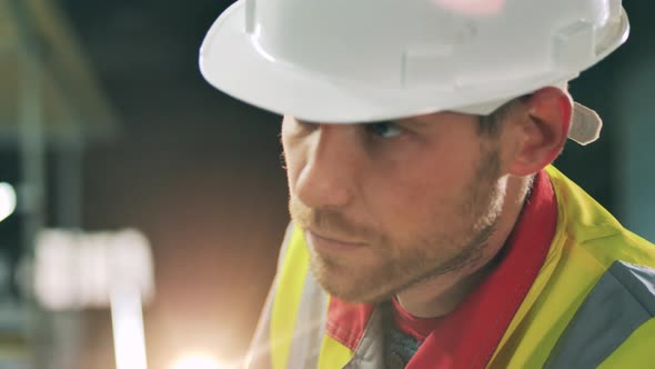Sideview of Bearded Worker Face at Metal Working Factory alt