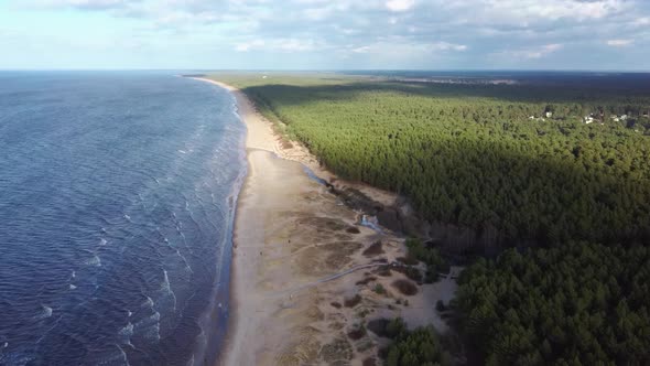 Garciems Beach, Latvia Baltic Sea Suny Winter Day Big Clouds Sand Dunes With Pine Trees. Aerial 4K alt