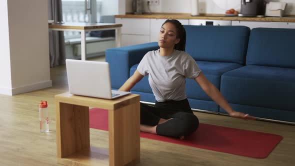 Young African Woman Doing Stretching Warming Up Her Joints in Front Laptop Slow Motion alt