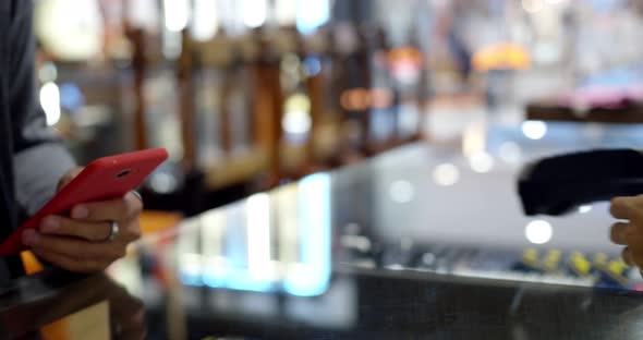 Young muslim man use smartphone paying over contactless transaction machine alt