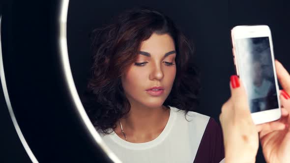 Closeup Shot of Young and Beautiful Woman Being Photographed with Mobile Phone in Front of the Ring alt