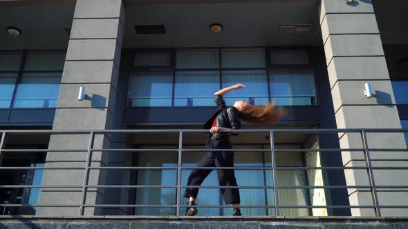 Blond Woman Street Dancer Performing near Metal Railings of Modern Building alt