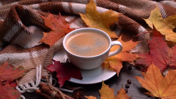 Autumn Fall Leaves Hot Cup of Coffee and Warm Plaid on a Wooden Table Background alt