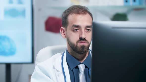 Close Up Shot of Tired and Exhausted Doctor Working on the Computer alt
