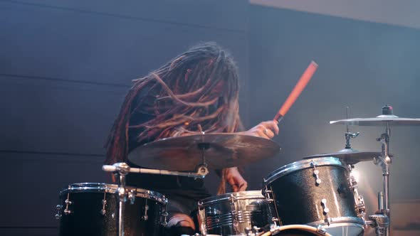 Talented Musician with Dreadlocks Play on Drums in Smoke in a Club alt