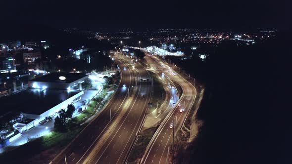 Aerial night shot of a bust highway with traffic in all lanes and street lights