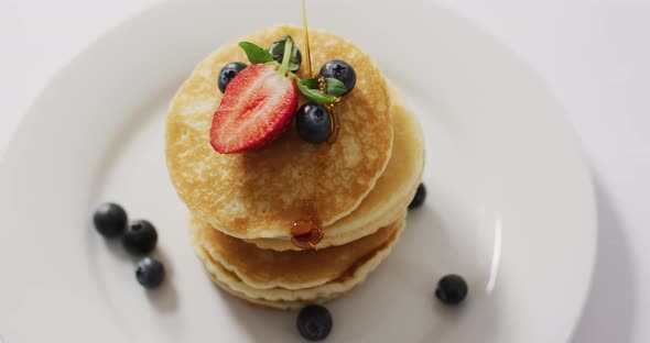 Video of pancakes on plate seen from above on white background alt