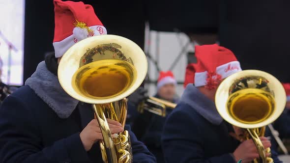 Brass Orchestra in Funny Hats Playing Christmas Carols Creating Holiday Spirit alt