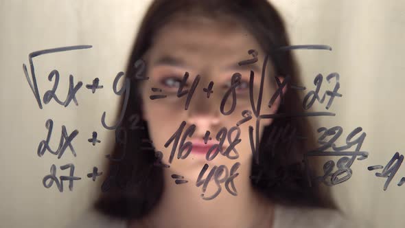 Woman Student Looking at Math Equation on Glass Whiteboard Thinking