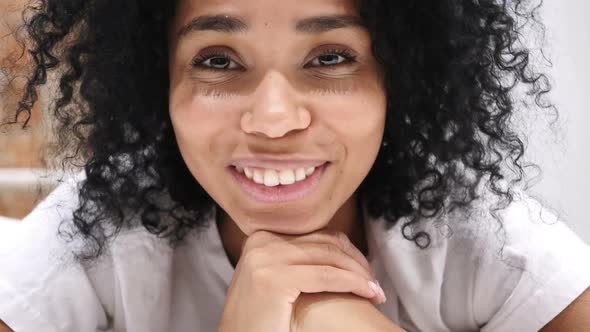 AfroAmerican Woman Lying on Stomach in Bed Smiling Looking in Camera Laughing alt