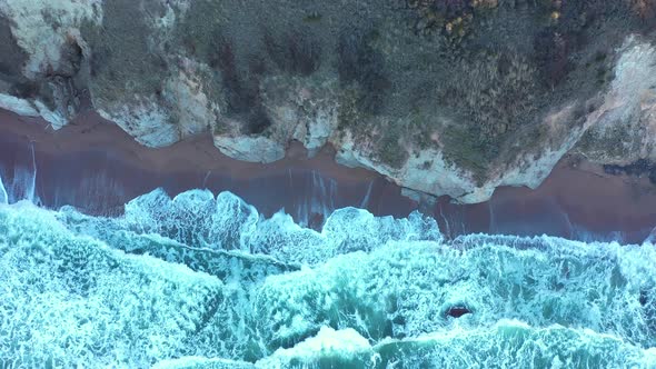 Aerial view to a beautiful wild rocky beach and big waves alt