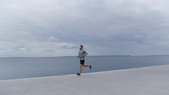 Man In Sportswear Jogging Along Promenade