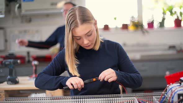 Female electrician working with wire cutter