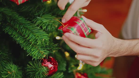 Asian man holding small gift box Christmas decorate Christmas tree.