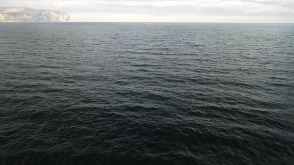 Aerial View From Above on Calm Azure Sea and Volcanic Rocky Shores alt