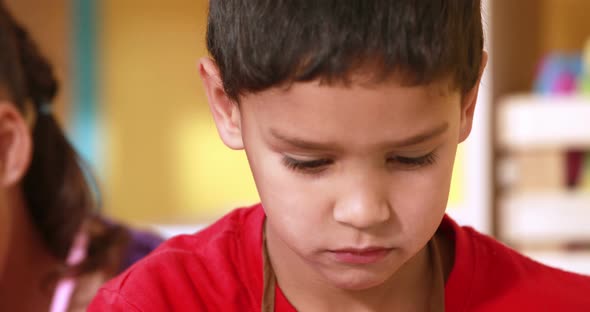 Preschool class painting at table in classroom alt