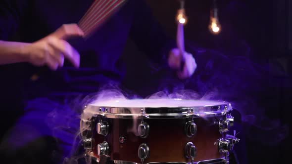 Drummer playing snare drum with smoke and beautiful lighting slow-motion.