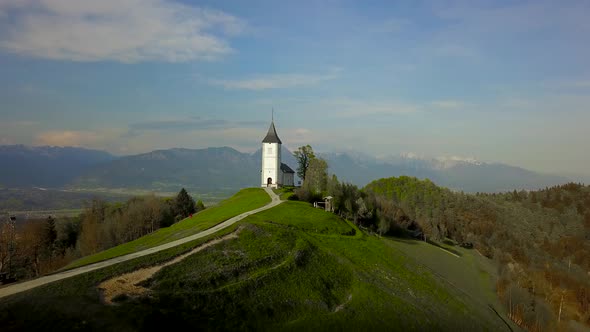 drone footage sunset at Church of St. Primus and Felician, Jamnik, Slovenia 12 alt