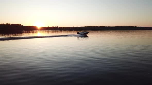  Motor Boat Floating on the River at Sunset