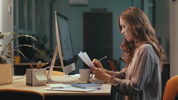 Focused Business Woman Working with Documents at Night Office alt