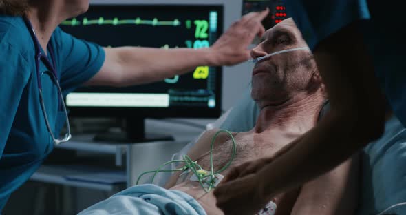 Doctors Placing Cables on Patient To Check Heart Rate alt