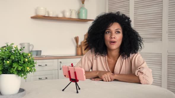 Cute African American Woman Communicates on a Video Call Using a Mobile Phone alt