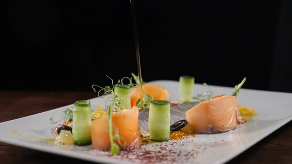 Slow Motion Restaurant Cooking Video. Close-up Shot of Chef Pouring Extra Virgin Olive Oil on Fish alt