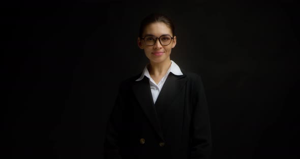 Asian Business Woman in Glasses and Formal Clothes Stands and Looks at Camera