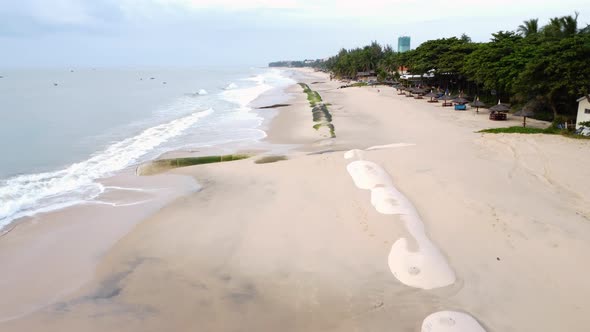 Aerial, beach in Vietnam with barriers to prevent climate change sea level rise alt