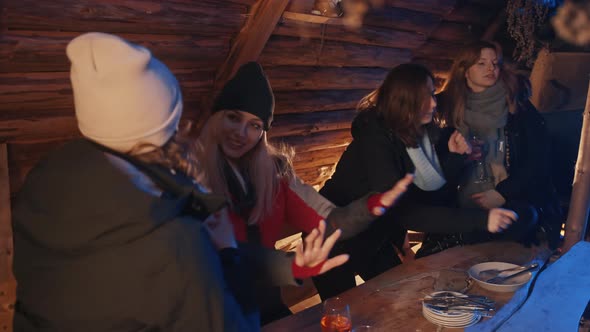 Happy Young Women Having Fun in the Wooden Cottage and Celebrating New Year alt
