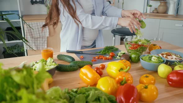 Pregnant Woman Preparing Organic Healthy Food Slicing Vegetables for Salad alt