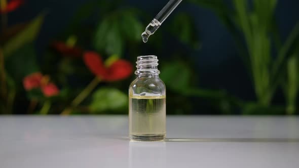 Aromatheraphy Oil Drops Dripping From Dropper Into a Bottle