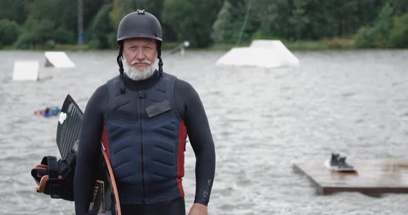 Wakeboarder, Portrait of Adult Man, Sportsman Stands Near the Lake, Looks at the Camera alt