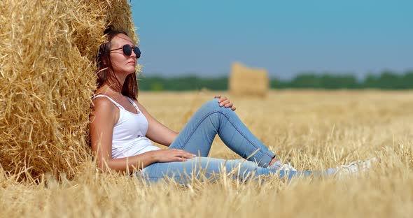 Portrait a Girl in Sunglasses Resting By a Golden Haystack Resting in Nature alt