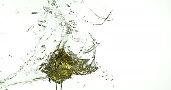 Glass of White Wine Breaking and Splashing against White Background, Slow motion 4K