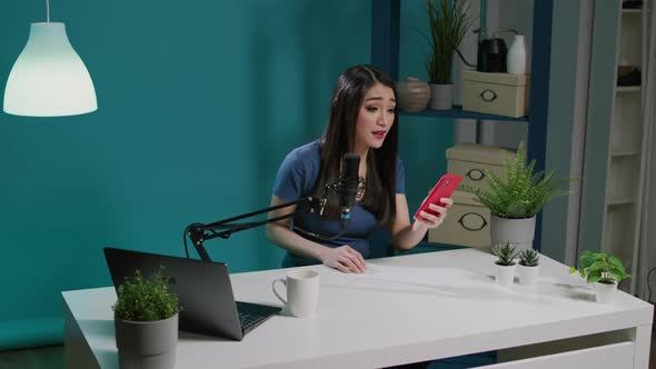 Female Blogger Answering Social Media Comments on Live Podcast alt