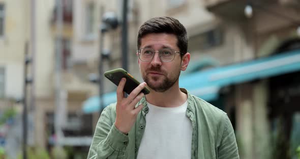 Man Making Voice Message or Using Virtual Assistant App on Mobile Phone alt