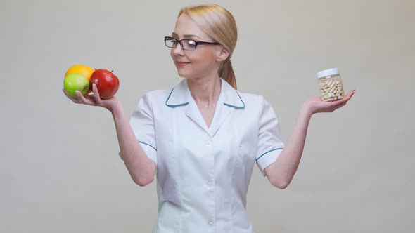 Nutritionist Doctor Healthy Lifestyle Concept - Holding Natural Organic Fruits and Can of Pills alt