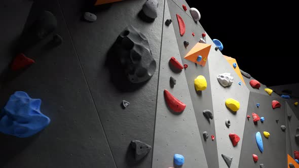 Indoor bouldering wall with colorful climbing holds. Gym indoor extreme training alt