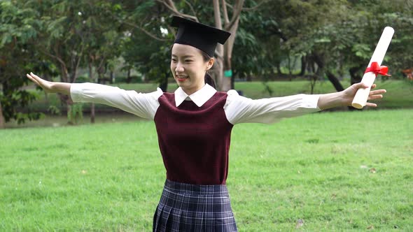 Young Asian Female Graduate Hugging Her Friend at Graduation Ceremony alt