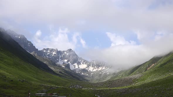 High Snowy Mountains on the Background of Glacial Valley and Alpine Meadows alt