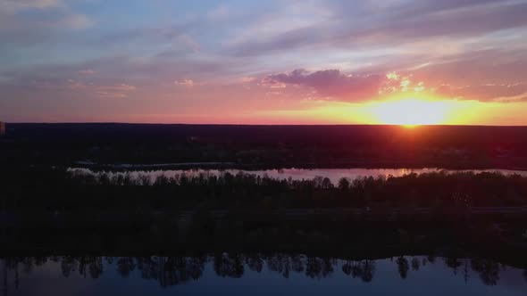 Colorful Sunset Over the Bay the Drone Slowly Flies Back in Front of the Forest and the Road Ukraine