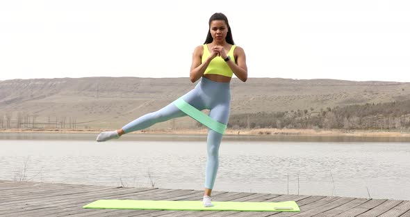 Fitness trainer with a rubber sports belt on hips. alt