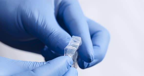 The Dentist checks the Quality of the Manufactured Teeth Whitening Splints. alt