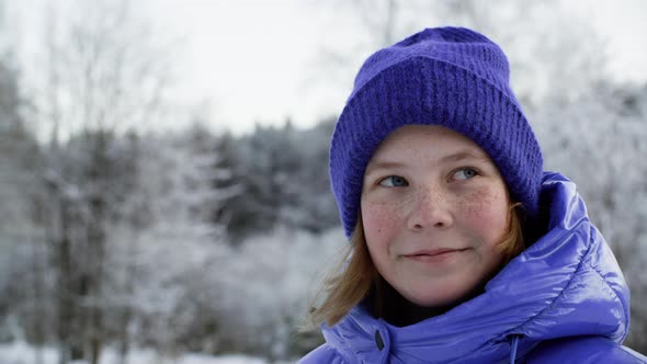 Face of Cute Smiling Girl Breathing and Looking Around Outdoors at Wintertime alt