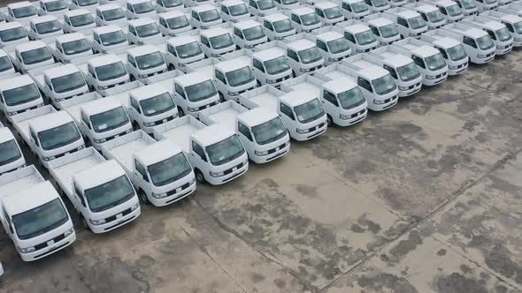 Aerial top view of new truck cars parking for sale stock lot row, dealer inventory alt