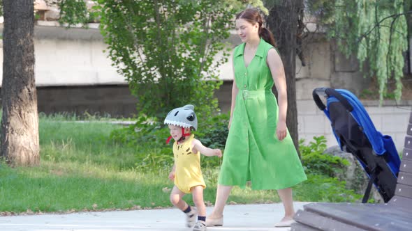Mother Teaches Her Toddler to Ride Balance Bike for Younger Kids Outdoors 1 alt