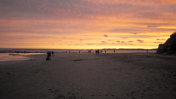 Sunset on an Australian beach during summer. People on the sand enjoying the beautiful evening, bike alt