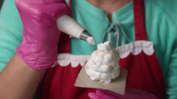 Woman Makes Marshmallow Cones. Using A Pastry Bag, On A Stand. Close Up Shot alt