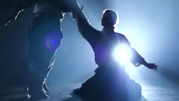 Aikido Master Technique Demonstration From a Sitting Position on Spotlight Background. Slow Motion alt